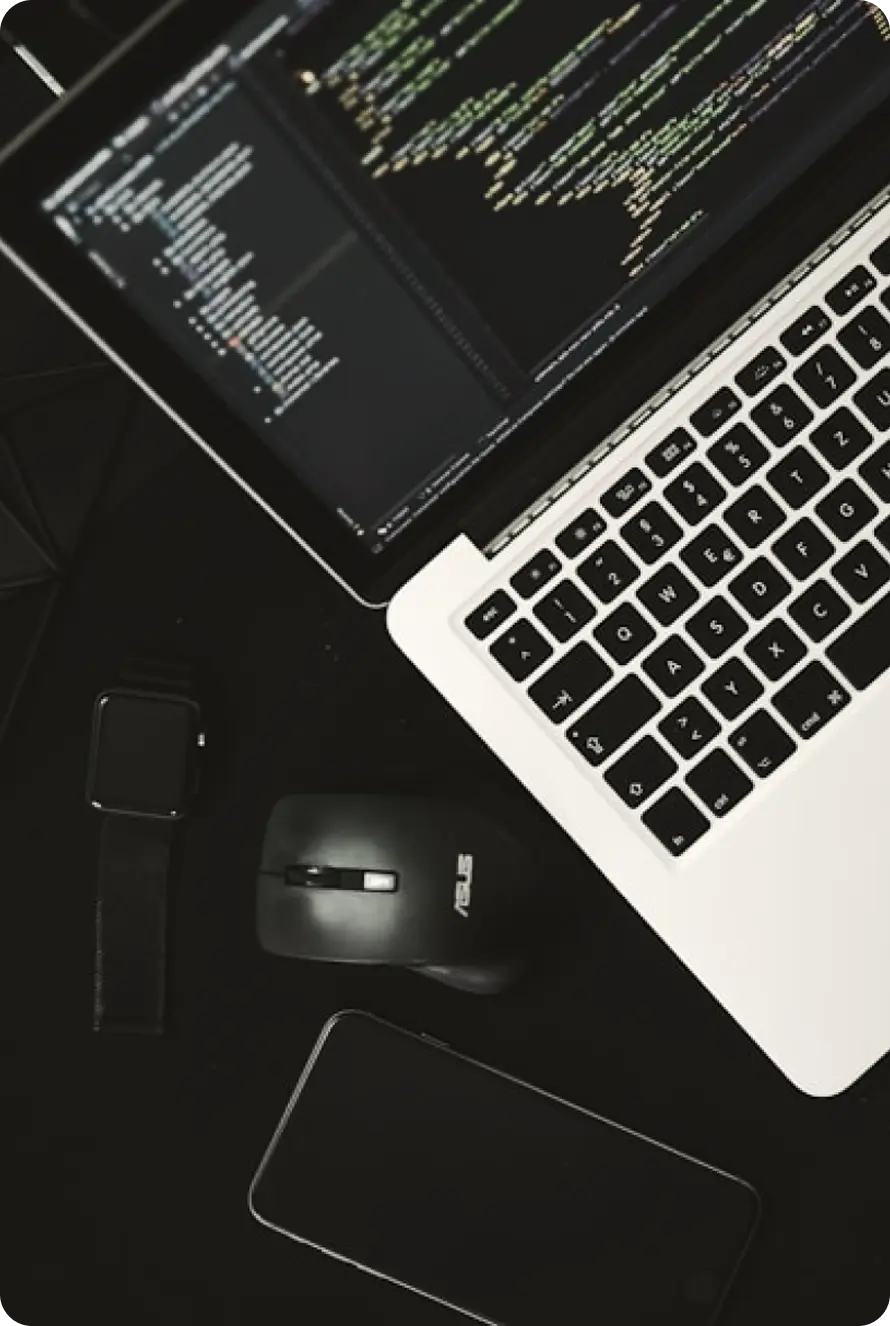 Laptop showing source code on a desk, illustrating secure platform development.
