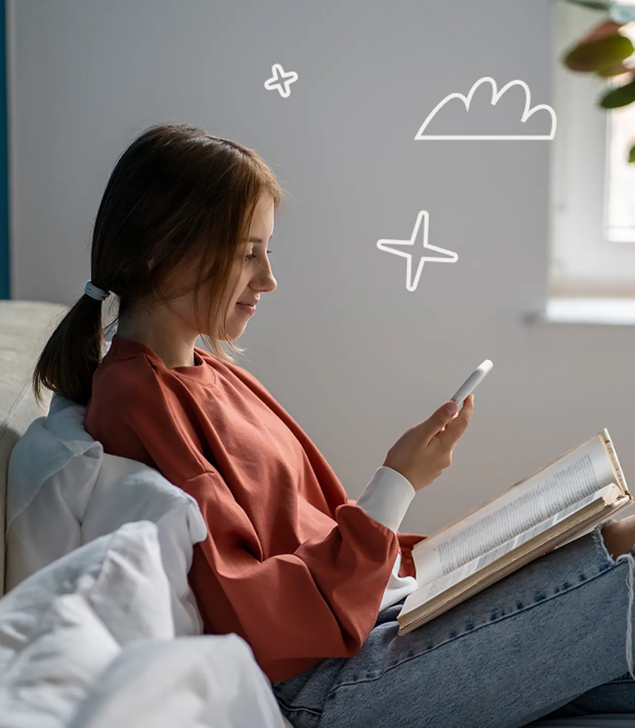 Woman relaxing indoors, reading a book with her phone in hand.