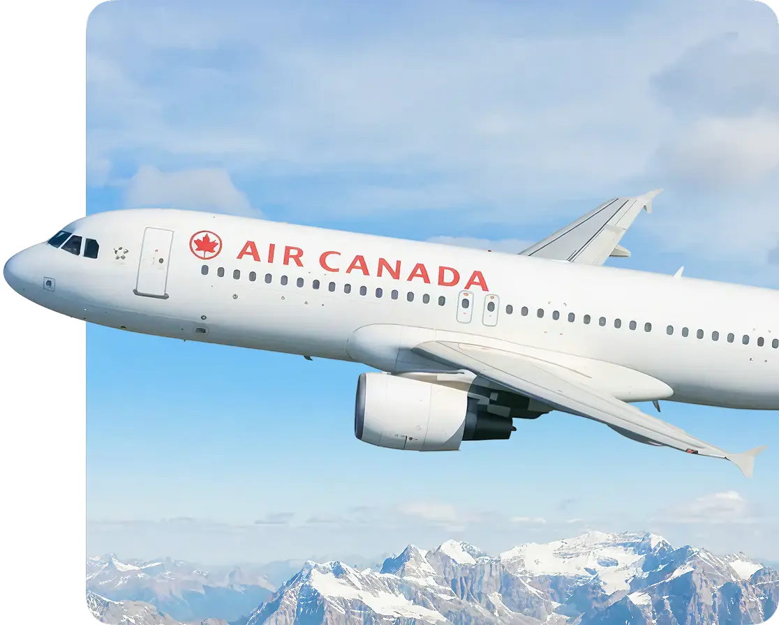 Passenger plane flying above snow-capped mountains.