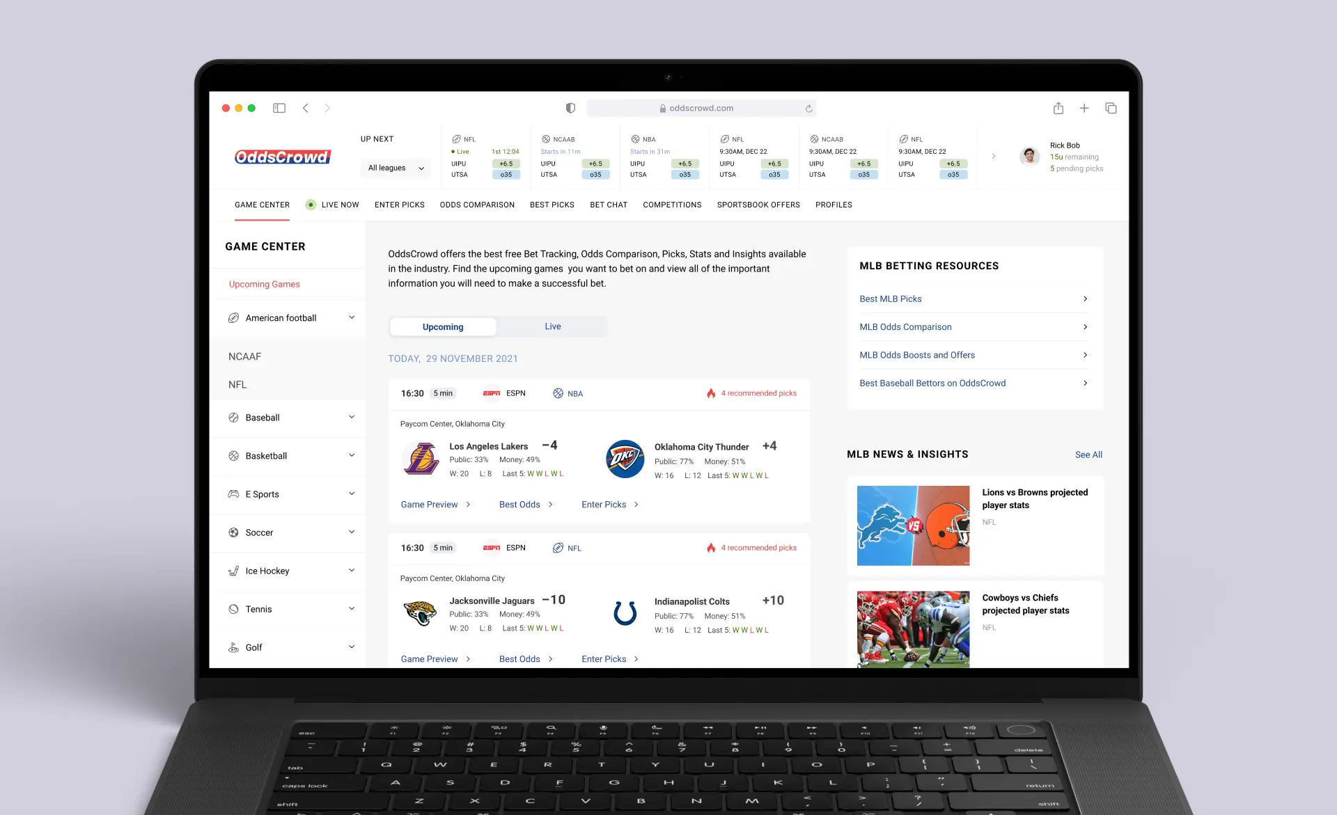 On the laptop screen, we see the Game Center page of the Oddscrowd app as an example of custom Laravel web development. The screen displays upcoming and live event announcements, a side menu with various sports types, scores of current games and leagues at the top, with two sections to the right dedicated to MLB news & insights and MLB betting resources.