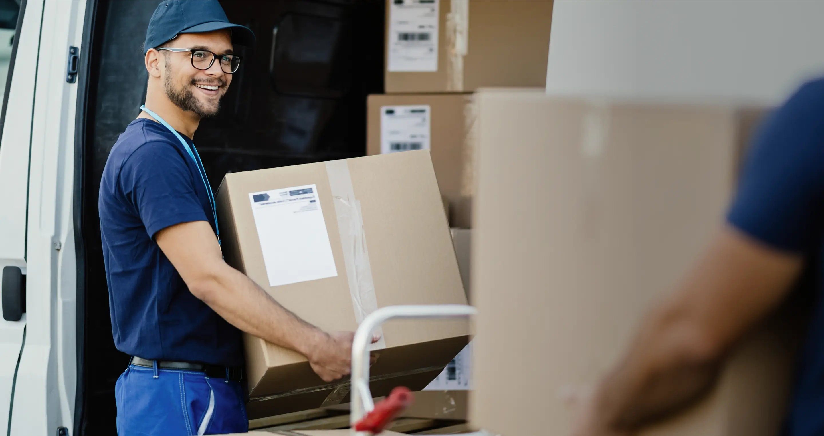 Courier loading parcels into a Drivery delivery van.