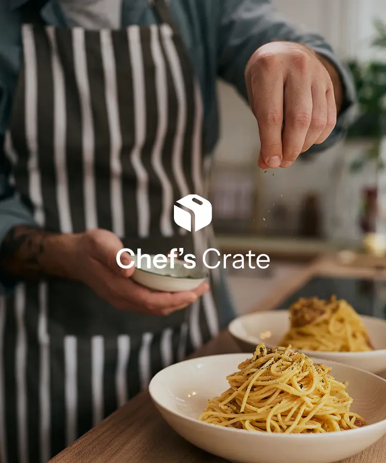 Cook in a striped apron seasoning bowls of pasta, with the Chef's Crate logo over the photo.