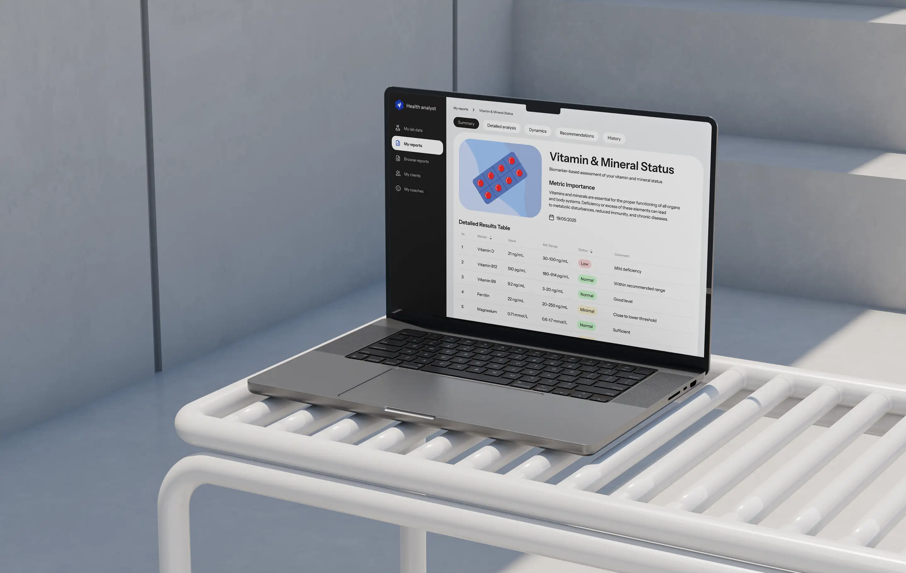 Laptop on a bench showing the Vitamin and Mineral Status report with a detailed results table.