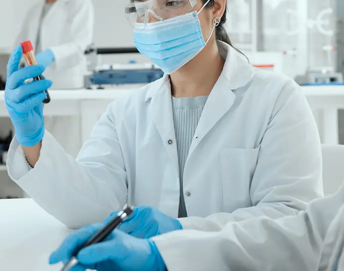 Lab technicians in white coats working in a clinical laboratory.